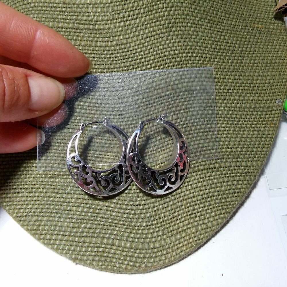 Women`s silver tone filigree hoop earrings. 1 1/8
